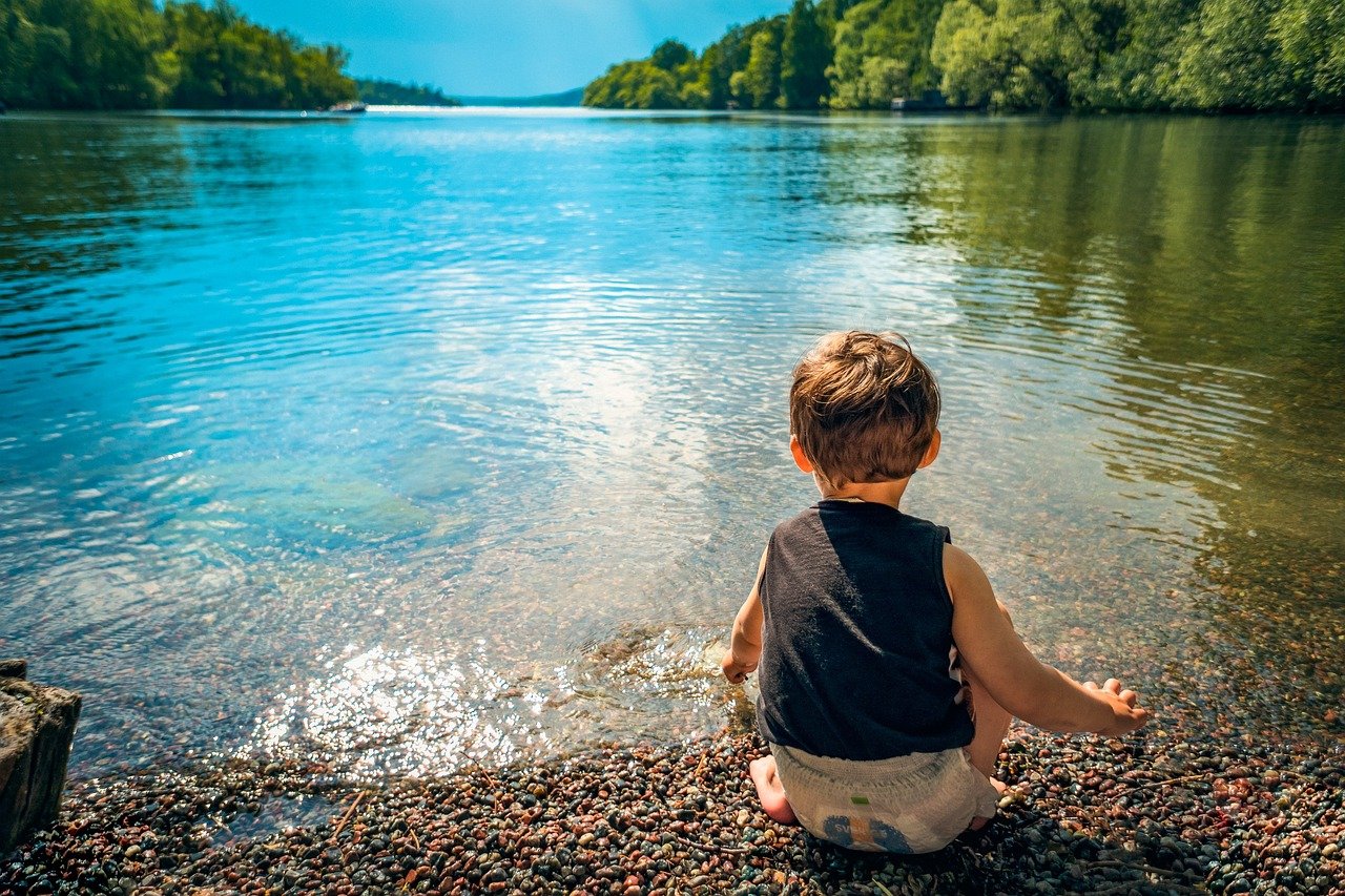 traveling with a boy sitting by the lake